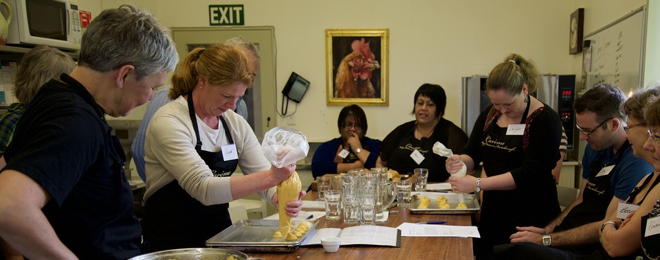 Students piping out profiteroles in Jo Crabb's Wasy French cooking class